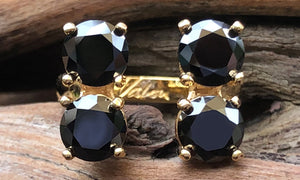 front view of a four-stone gold plated ring with black CZ crystals 