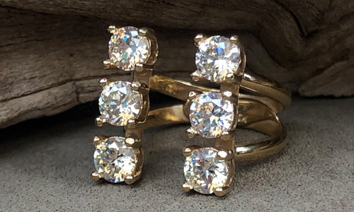 side view of a six-stone gold plated ring with clear CZ crystals