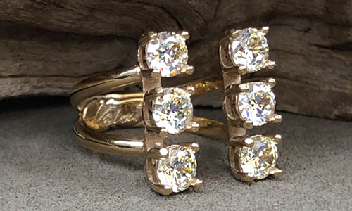 side view of a six-stone gold plated ring with clear CZ crystals