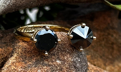 front view of a 14k gold plated ring with two black CZ crystals