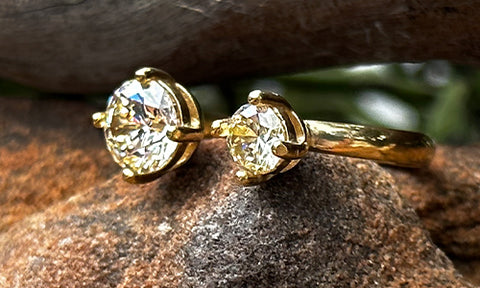 side view of a 14k gold plated ring with two clear CZ crystals