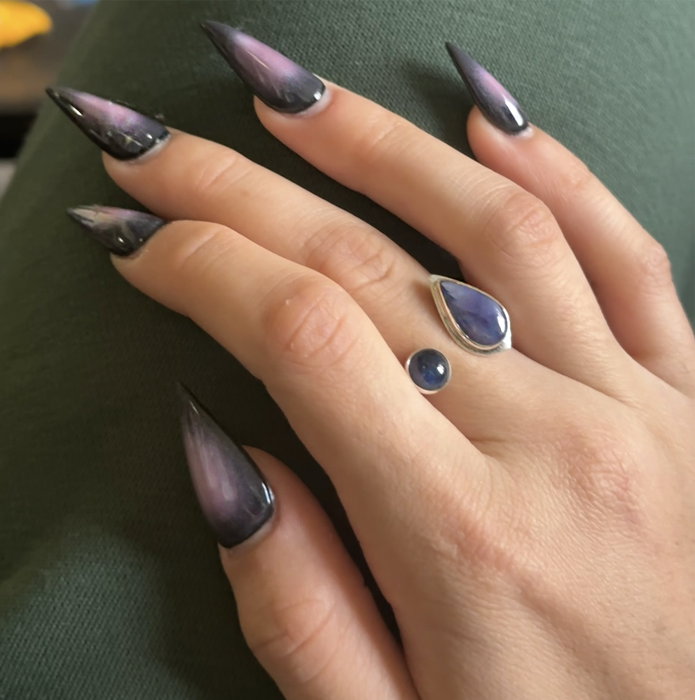 Hand with long, manicured pointed nails and a color matching 2cap ring 