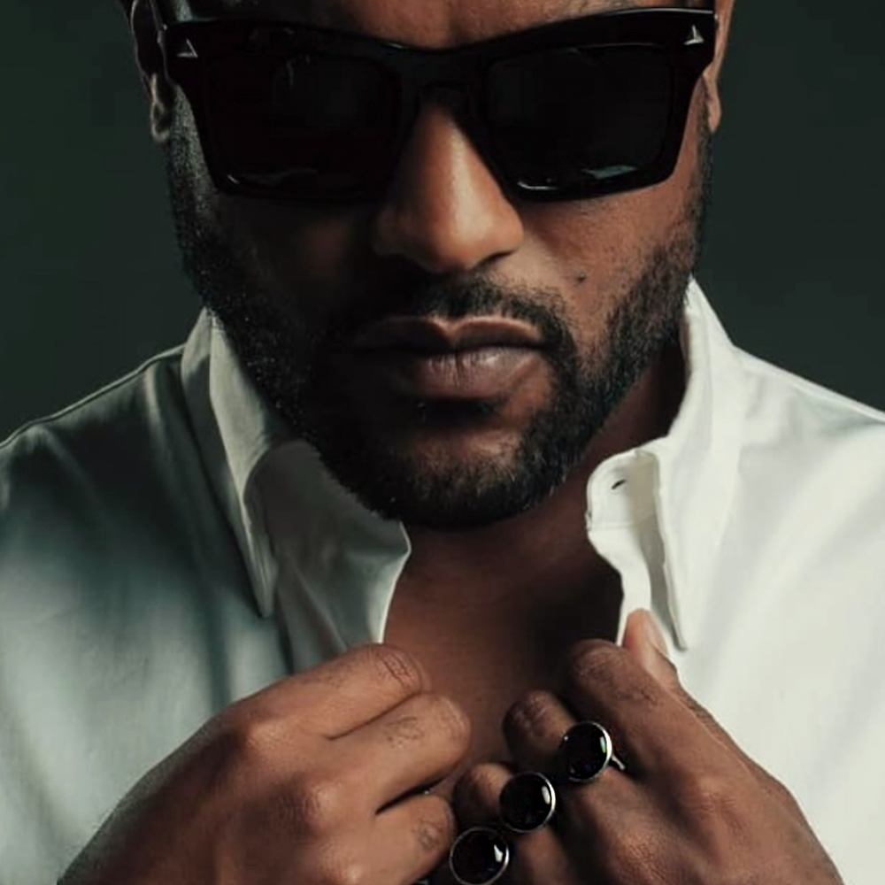 Man wearing sunglasses, a white shirt with an Onyx Valou 3cap ring (double finger ring for men)