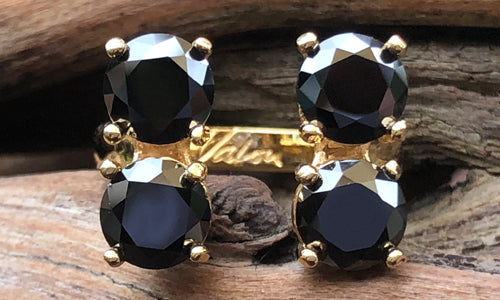 front view of a four-stone gold plated ring with black CZ crystals 