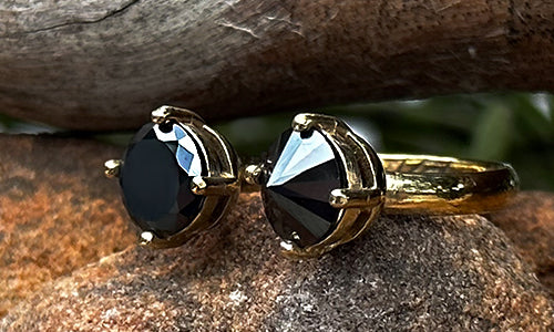 side view of a 14k gold plated ring with two black CZ crystals